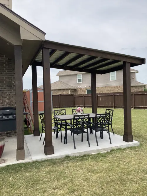 Stained patio cover extending a covered porch over a new concrete dining slab
