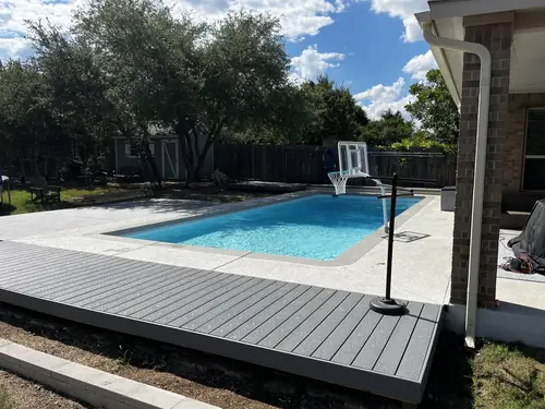 Composite deck laid flush to the concrete coping of a backyard pool