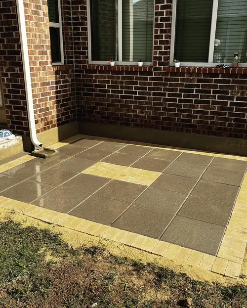 Paver patio with a contrasting brick border laid against a brick home