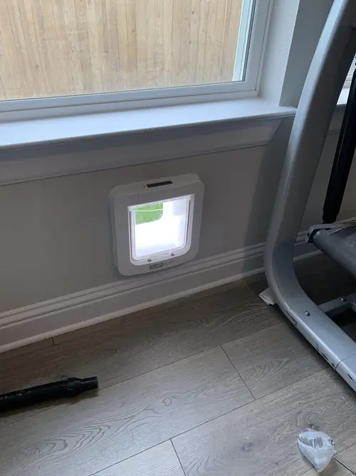 Pet door fitted neatly into an interior wall below a window