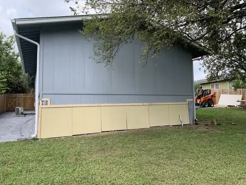 Fresh siding panels installed along the lower wall of a home